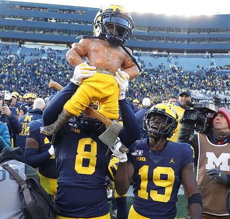 Paul Bunyan Trophy, Devin Gil (8), and Mike Sainristil (19)