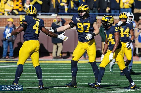 DJ Turner (5), Aidan Hutchinson (97), Josh Metellus (14), and Cameron McGrone (44)
