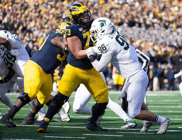 Michael Onwenu (50) and Jalen Mayfield (73)
