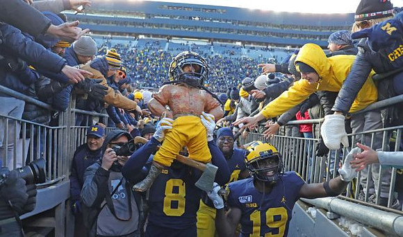 Paul Bunyan Trophy, Devin Gil (8), and Mike Sainristil (19)