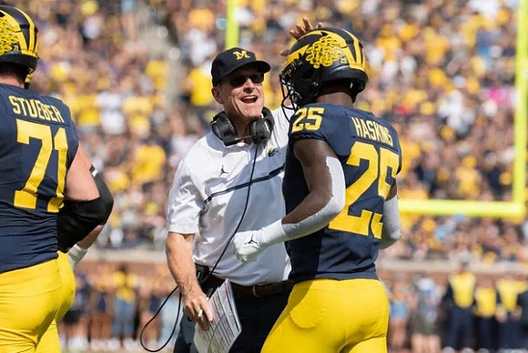 Andrew Stueber (71), Jim Harbaugh, and Hassan Haskins (25)