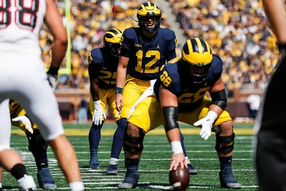 Hassan Haskins (25), Cade McNamara (12), and Andrew Vastardis (68)