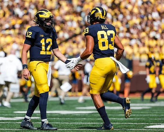Cade McNamara (12), and Erick All (83)