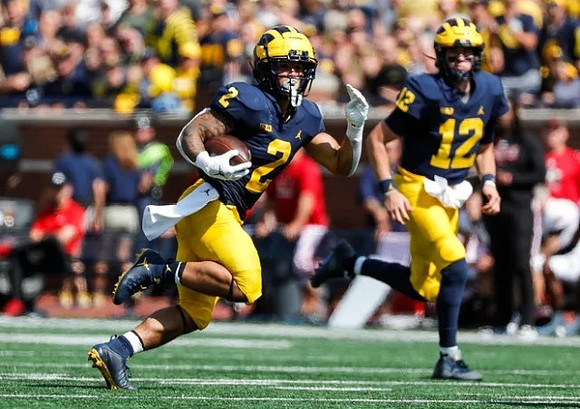 Blake Corum (2), and Cade McNamara (12)