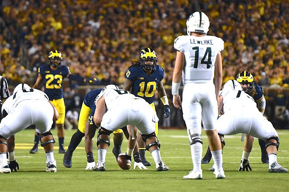 Tyree Kinnel (23), Devin Bush (10), and Chase Winovich (15)