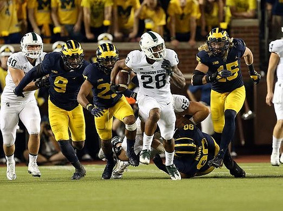 Mike McCray (9), Tyree Kinnel (23), Bryan Mone (90), and Chase Winovich (15)