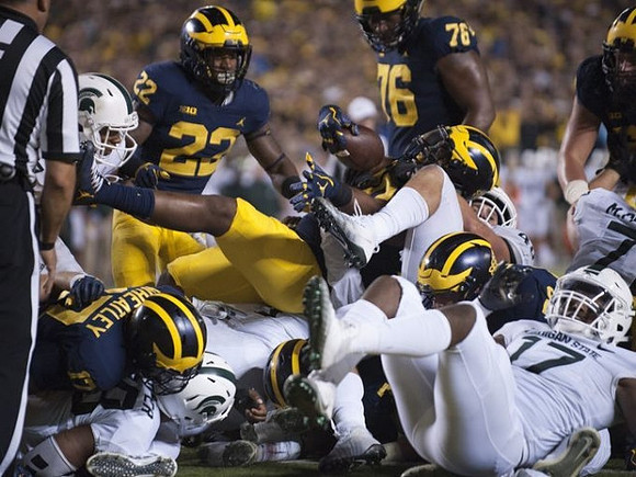 Tyrone Wheatley Jr. (17), Karan Higdon (22), and Juwann Bushell-Beatty (76)