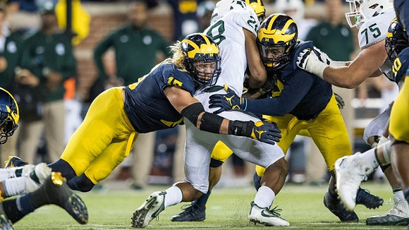 Chase Winovich (15), Mike McCray (9), and Devin Bush (10)