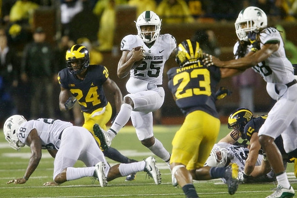 Lavert Hill (24), Tyree Kinnel (23), and Chase Winovich (15)