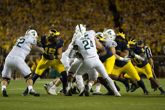 Chase Winovich (15), Bryan Mone (90), and Devin Bush (10)