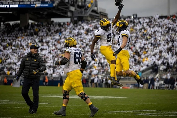 Jim Harbaugh, Andrew Vastardis (68), Mike Sainristil (5), and Roman Wilson (14)