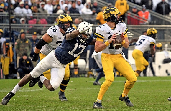 Ryan Hayes (76), Cade McNamara (12), and Mike Sainristil (5)