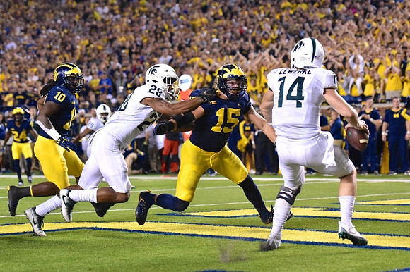 Lavert Hill (24), Devin Bush (10), and Chase Winovich (15)