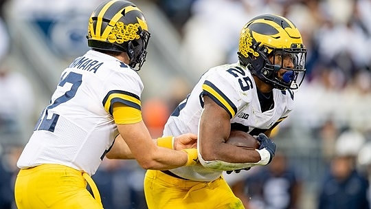 Cade McNamara (12) and Hassan Haskins (25)