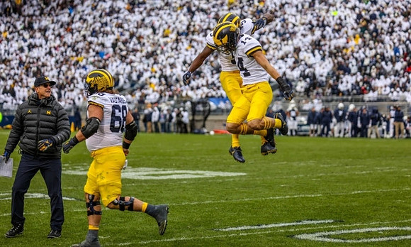 Jim Harbaugh, Andrew Vastardis (68), Mike Sainristil (5), and Roman Wilson (14)