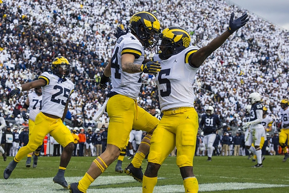 Andrew Stueber (71), Hassan Haskins (25), Roman Wilson (14), and Mike Sainristil (5)