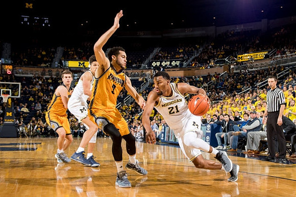 D.J. Wilson (5) and Zak Irvin (21)