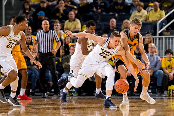 Zak Irvin (21), Derrick Walton Jr. (10), and Duncan Robinson (22)
