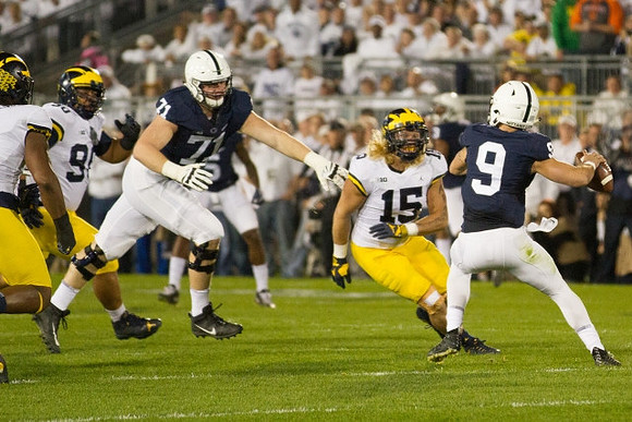 Bryan Mone (90) and Chase Winovich (15)