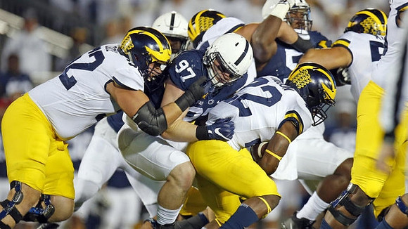 Mason Cole (52), Karan Higdon (22), and Ben Bredeson (74)
