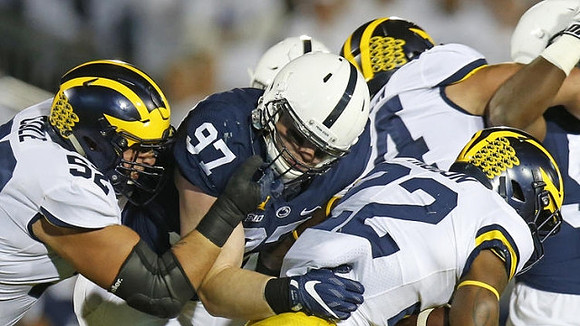 Mason Cole (52), Karan Higdon (22), and Ben Bredeson (74)