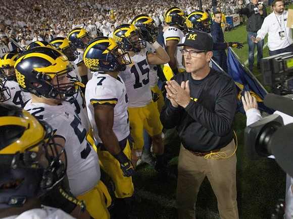 Mason Cole (52), Khaleke Hudson (7), Chase Winovich (15), and Jim Harbaugh