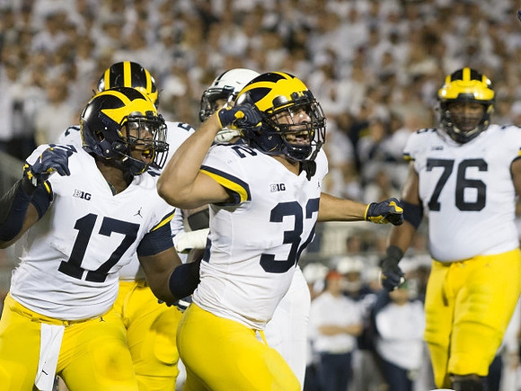 Tyrone Wheatley Jr. (17), Ty Isaac (32), and Juwann Bushell-Beatty (76)