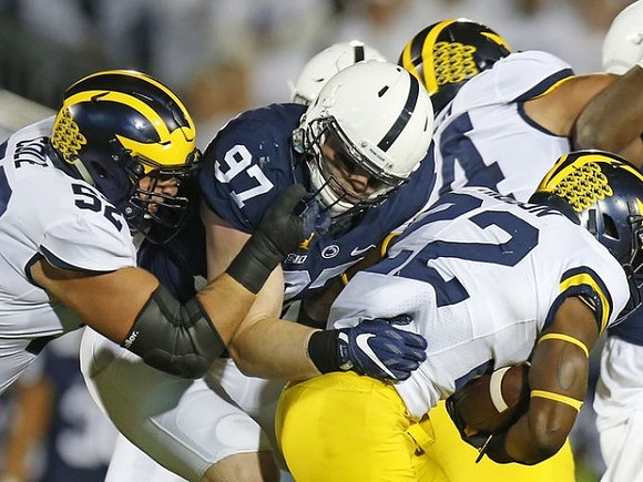 Mason Cole (52), Karan Higdon (22), and Ben Bredeson (74)