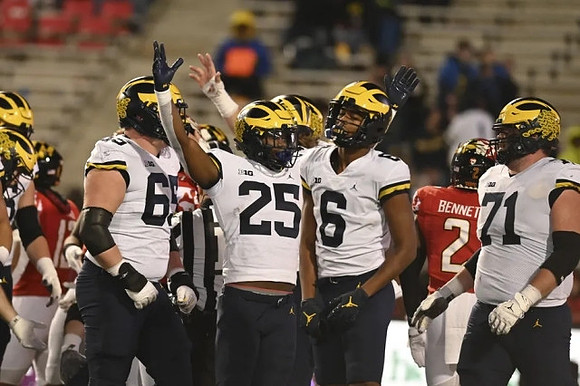 Zak Zinter (65), Hassan Haskins (25), Cornelius Johnson (6), and Andrew Stueber (71)