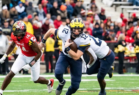 Cade McNamara (12) and Hassan Haskins (25)