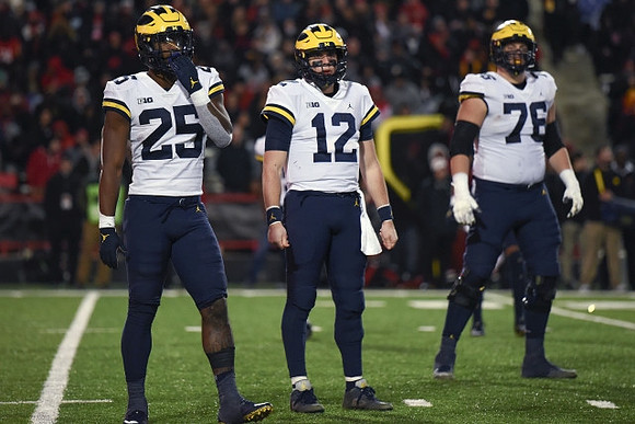 Hassan Haskins (25), Cade McNamara (12), and Ryan Hayes (76)