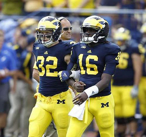 Jordan Kovacs (32) and Denard Robinson (16)