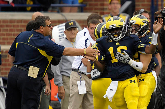 Brady Hoke, Denard Robinson (16), and Jordan Kovacs (32)