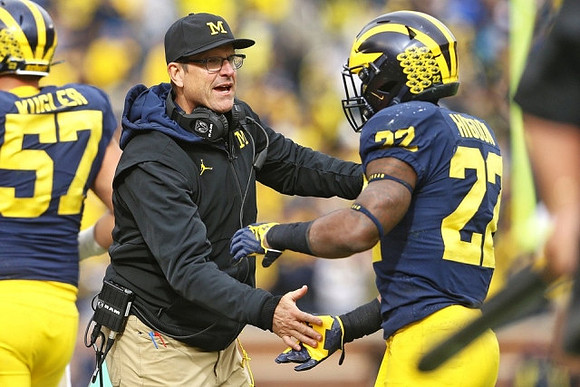 Patrick Kugler (57), Jim Harbaugh, and Karan Higdon (22)