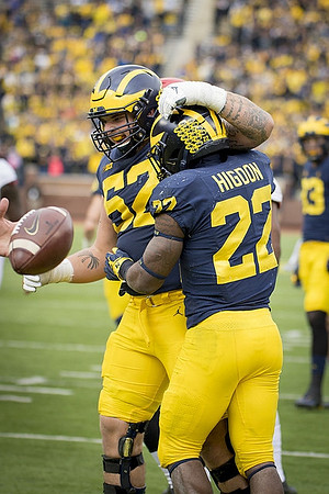 Mason Cole (52) and Karan Higdon (22)