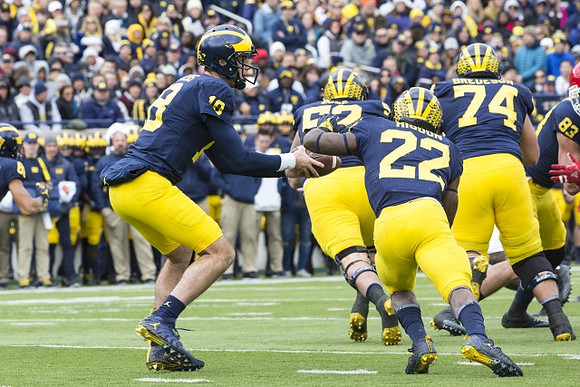 Brandon Peters (18), Mason Cole (52), Karan Higdon (22), Ben Bredeson (74), and Zach Gentry (83)