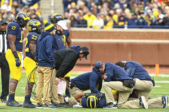 Tyrone Wheatley Jr. (17), Karan Higdon (22), Jay Harbaugh, Jim Harbaugh, and Ty Isaac (32)