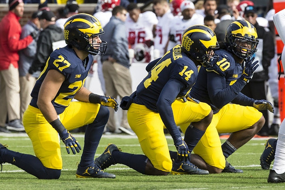 Joe Hewlett (27), Josh Metellus (14), and Devin Bush (10)