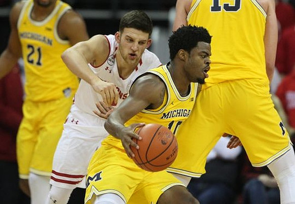 Zak Irvin (21), Derrick Walton Jr. (10), and Moritz Wagner (13)