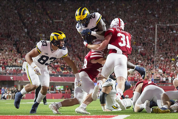 Erick All (83), Hassan Haskins (25), and Andrew Vastardis (68)