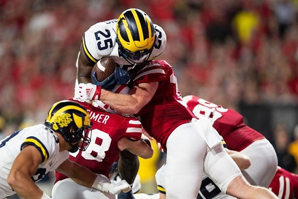 Erick All (83) and Hassan Haskins (25)