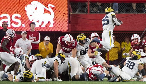 Cade McNamara (12), Luke Schoonmaker (86), Hassan Haskins (25), and Andrew Vastardis (68)