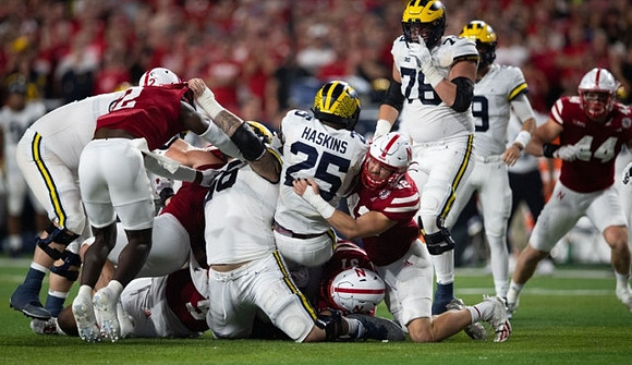 Chuck Filiaga (66), Hassan Haskins (25), Ryan Hayes (76), and J.J. McCarthy (9)