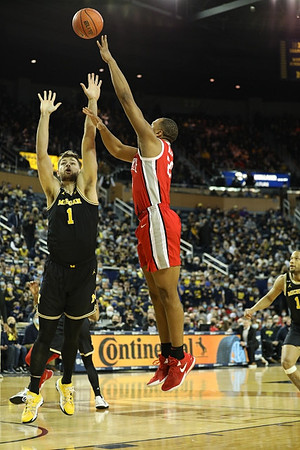 Hunter Dickinson (1) and DeVante' Jones (12)