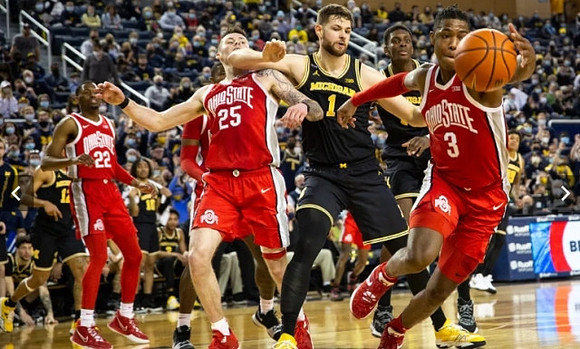 Hunter Dickinson (1), Moussa Diabate (14), and DeVante' Jones (12)
