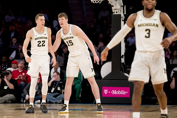 Duncan Robinson (22), Jon Teske (15), and Zavier Simpson (3)