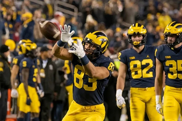 Erick All (83) and Michigan Team