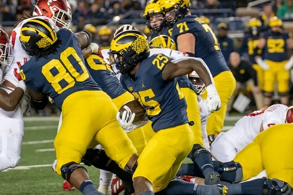 Trente Jones (80), Hassan Haskins (25), and Andrew Stueber (71)