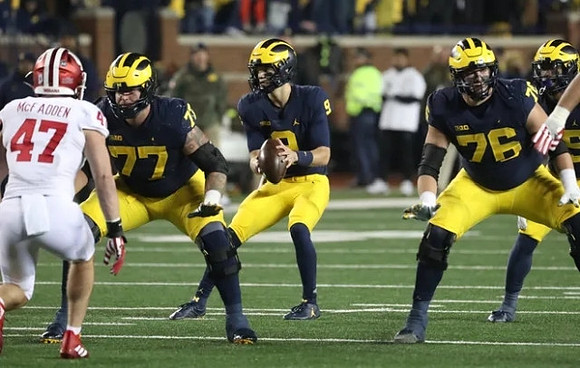 Trevor Keegan (77), J.J. McCarthy (9), and Ryan Hayes (76)