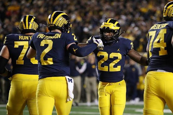 Jon Runyan Jr. (75), Shea Patterson (2), Karan Higdon (22), and Ben Bredeson (74)